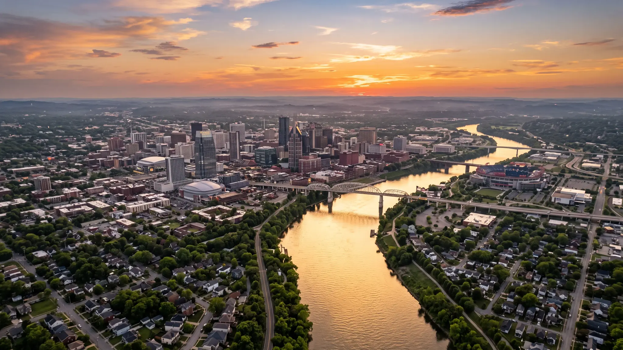 Aerial view of the Cumberland River winding past the Nashville skyline and Middle Tennessee neighborhoods at sunset